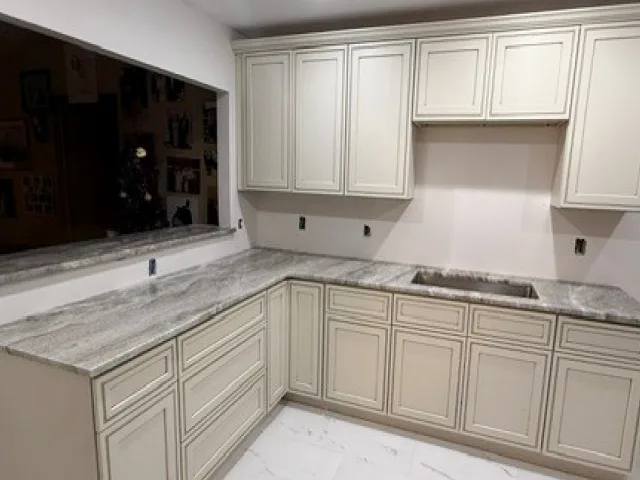 Kitchen renovation with new cabinets, stone counters and a tile backsplash
