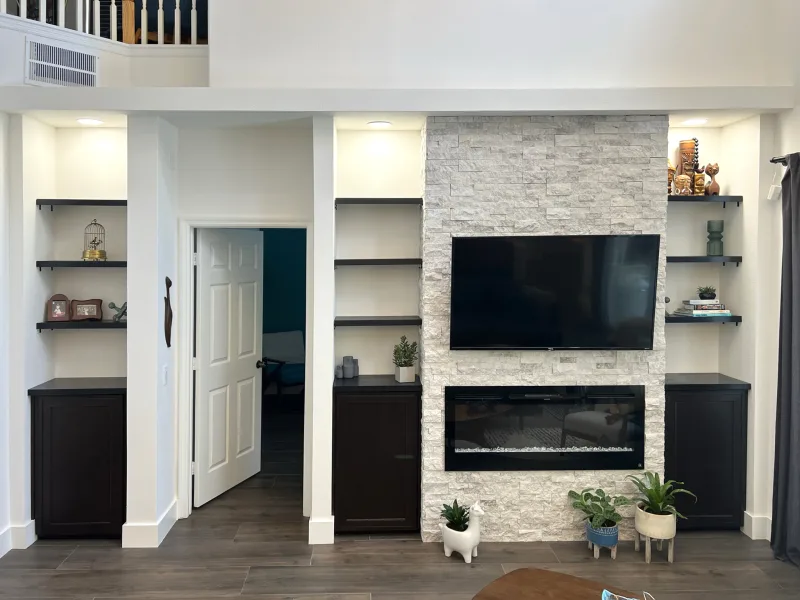 Renovated open living space with new flooring, fresh paint and a stone feature wall