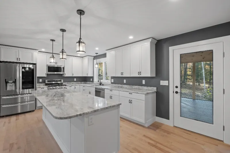 Finished kitchen with white shaker cabinets, a granite topped island and stainless steel appliances