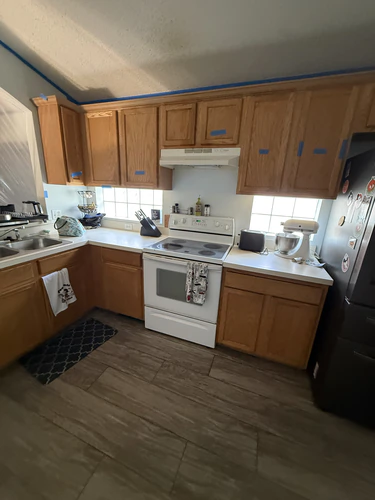 Orlando kitchen before the renovation, with oak cabinets, white laminate counters, a white range and a textured ceiling taped along the edge